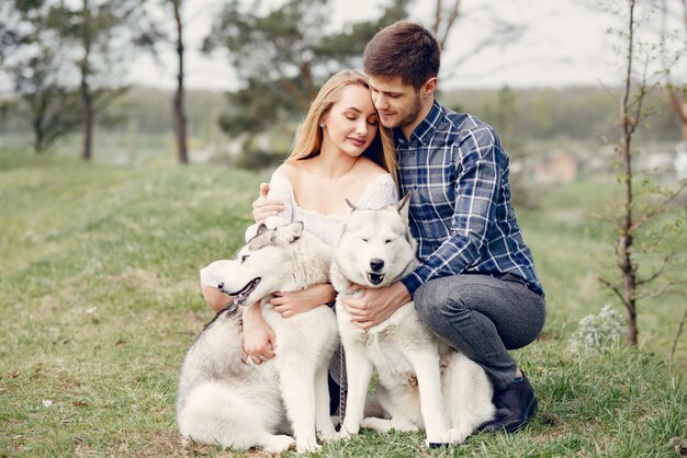 Lindo casal em uma floresta de verão com um cachorro