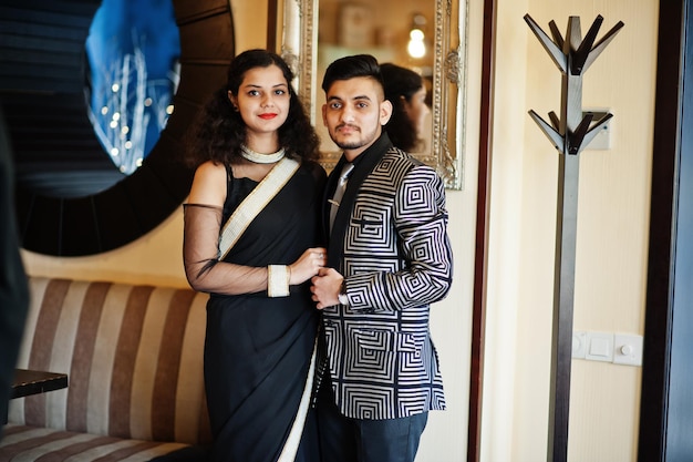 Foto grátis lindo casal indiano apaixonado veste saree e terno elegante posado no restaurante