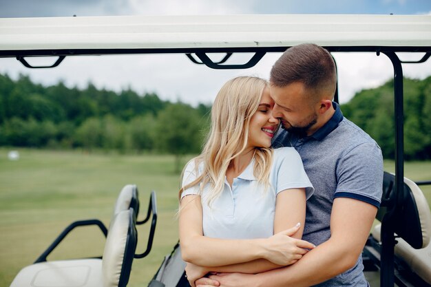 Foto grátis lindo casal jogando golfe em um campo de golfe