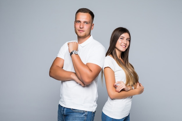 Lindo casal jovem em roupas casuais, isolado em um fundo cinza claro, vestido com camiseta branca