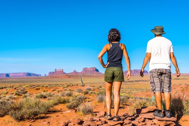 Lindo casal jovem europeu apreciando a bela vista do famoso Monument Valley em Utah, EUA