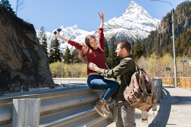 Lindo casal jovem hippie apaixonado, sentado na estrada