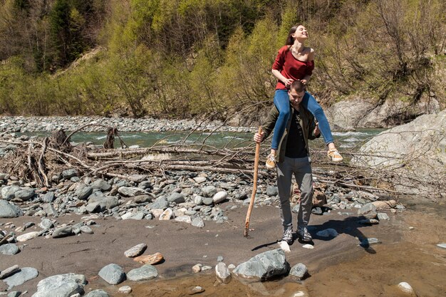 Lindo casal jovem hippie caminhando em um rio na floresta