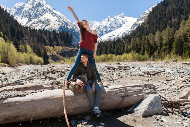 Lindo casal jovem hippie caminhando em um rio na floresta