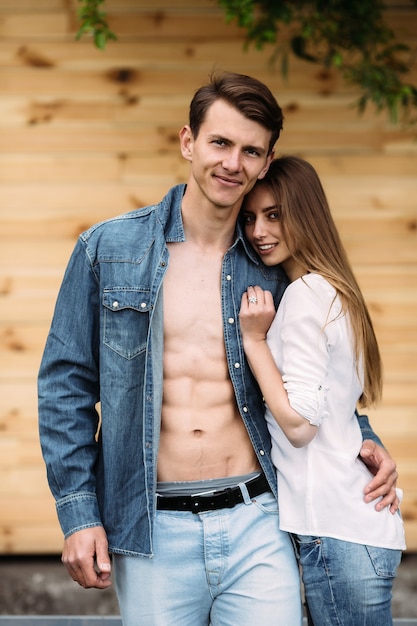 Lindo casal jovem posando em uma parede de madeira
