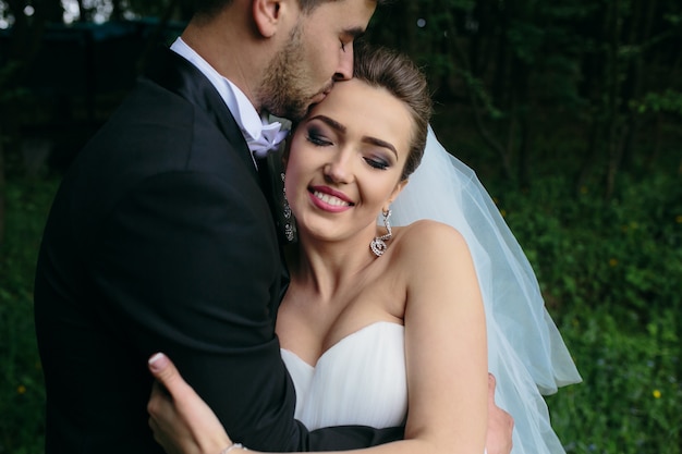 Lindo casal jovem posando na floresta de um ângulo próximo