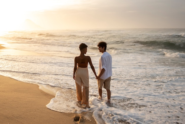 Lindo casal mostrando carinho na praia perto do mar