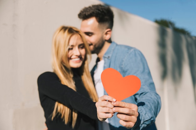 Lindo casal mostrando coração decorativo