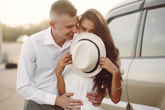 Lindo casal passa o tempo em um parque de verão perto de um carro