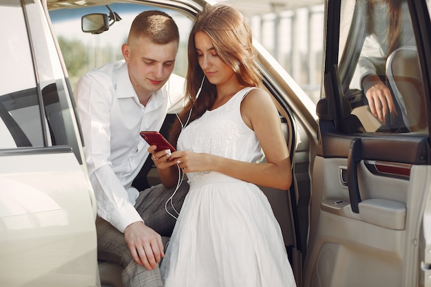 Lindo casal passa o tempo em um parque de verão perto de um carro