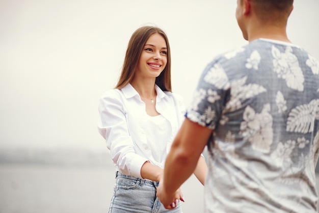 Lindo casal passa o tempo em um parque nublado outono