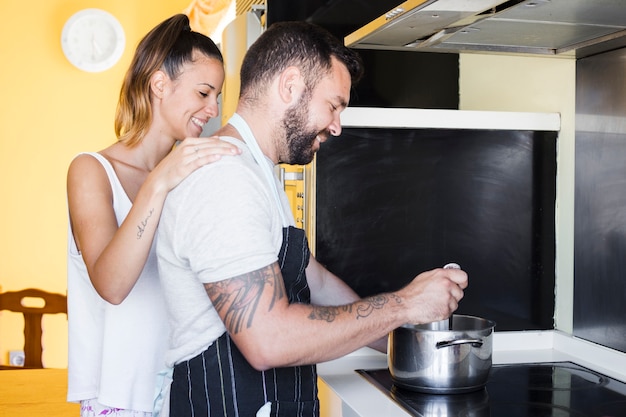 Lindo casal preparando comida no fogão de indução