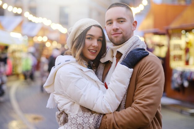 Lindo casal romântico aproveita o dia de Natal no tradicional mercado festivo.