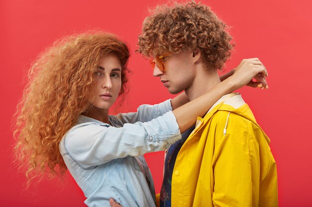 Lindo casal romântico com cabelo ruivo cacheado e roupas elegantes se abraçando