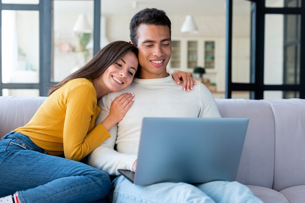 Lindo casal usando um laptop no sofá