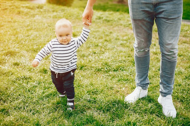 lindo pai alto e elegante em uma camisola e jeans está batendo com seu pequeno filho doce