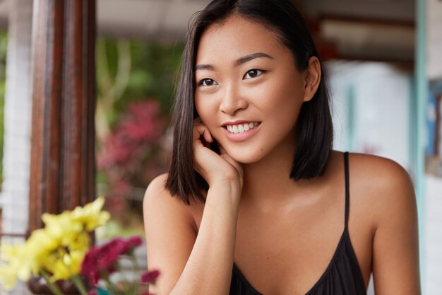 lindo retrato de uma mulher chinesa com penteado cortado, poses em quarto aconchegante