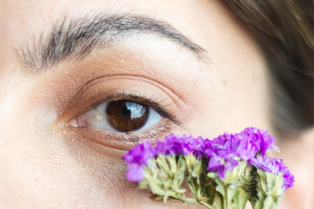 Foto grátis lindos olhos castanhos de mulher e sobrancelhas grossas e perfeitas com lindas florzinhas secas embaixo dos olhos