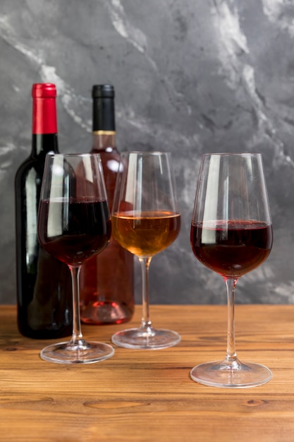 Linha de garrafas de vinho e taças de vinho
