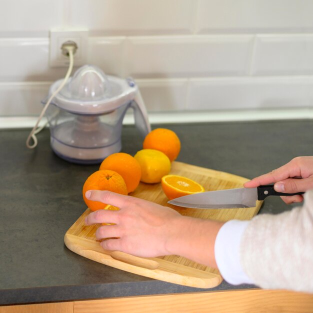 Linha de laranjas e faca na cozinha
