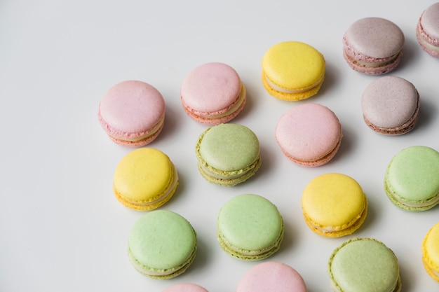 Foto grátis linha de macaroon cozido na mesa branca