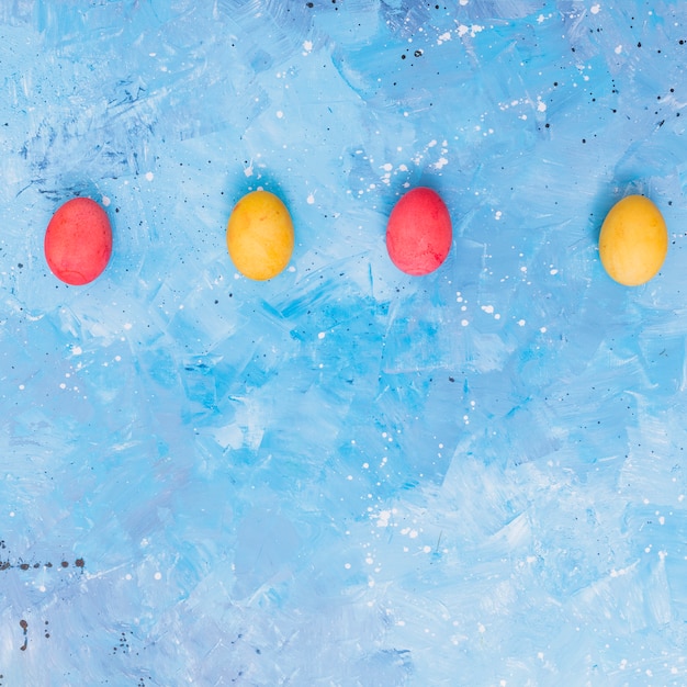 Foto grátis linha de ovos de páscoa coloridos na mesa