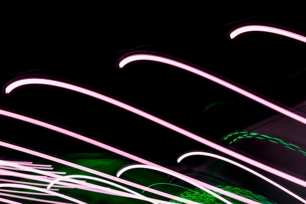 Foto grátis linhas de luz verdes e rosa abstraem fundo preto