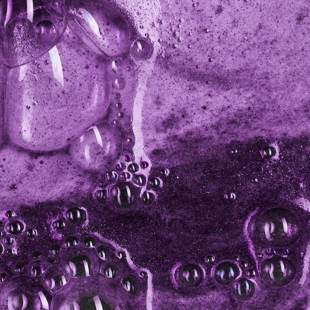 Líquido violeta com espuma leve e gotas