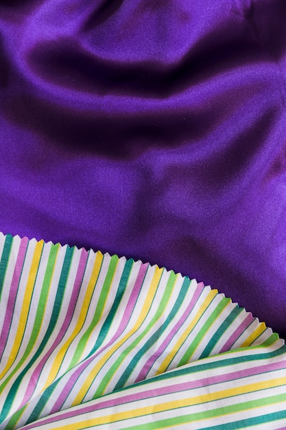 Foto grátis listras coloridas padrão toalha de mesa em tecido roxo liso