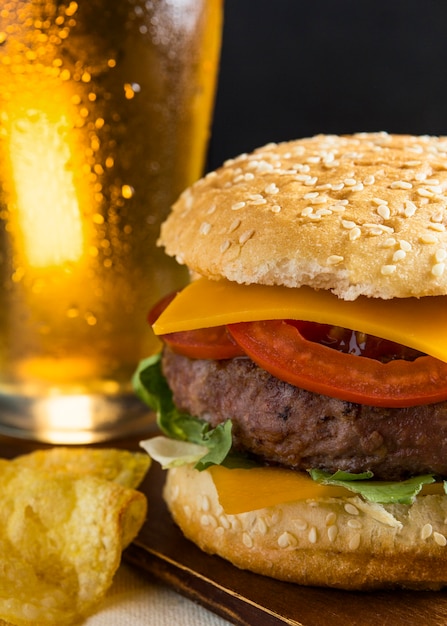 Litro de cerveja com cheeseburger e batatas fritas