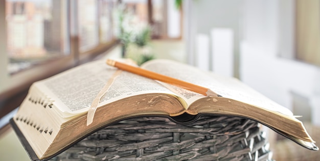 Livro Bíblia com close-up de lápis, no fundo de um belo terraço. Hora da manhã.