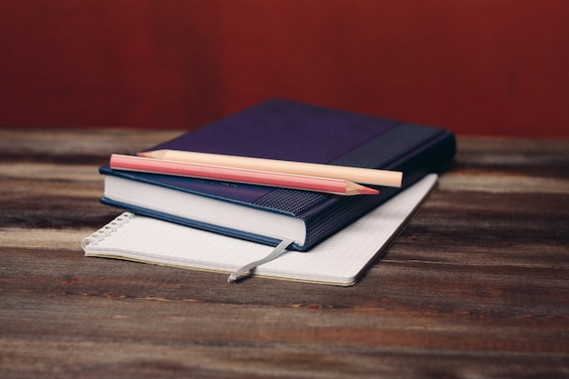 Livro com bloco de notas lápis objeto de documentos de escritório na mesa de madeira