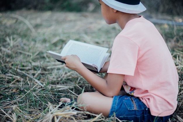 Foto grátis livro de leitura alegre do rapaz pequeno