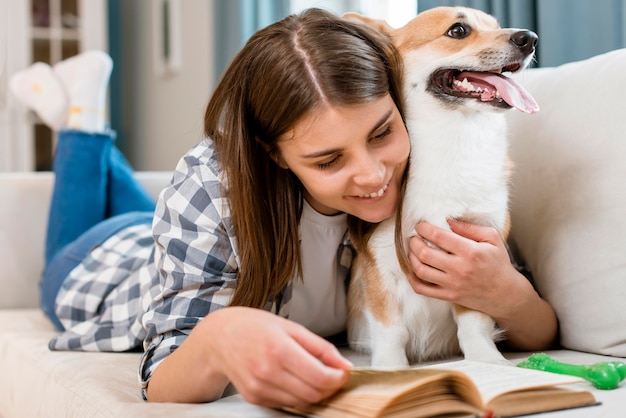 Livro de leitura da mulher no sofá com cachorro