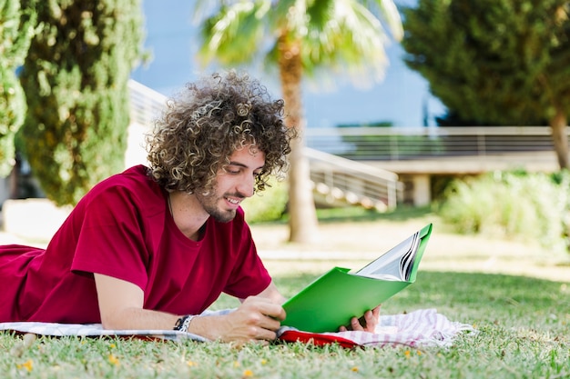 Livro de leitura de homem bonito no parque