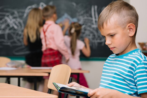 Livro de leitura de menino em sala de aula