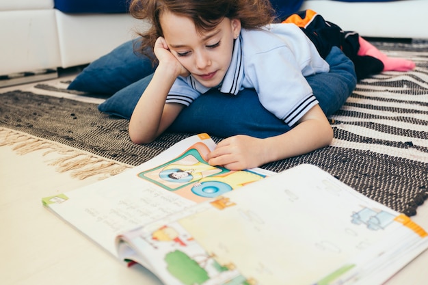 Livro de leitura de menino no chão