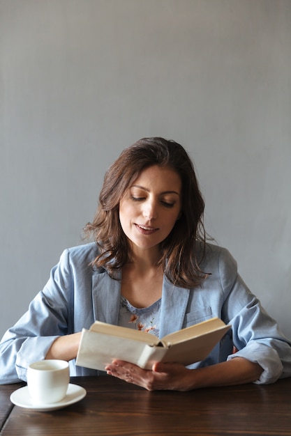 Foto grátis livro de leitura de mulher séria.