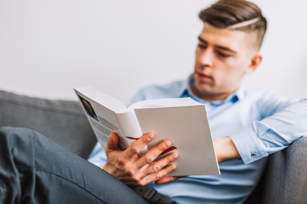 Foto grátis livro de leitura do homem turva no sofá