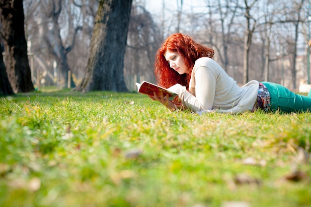 Livro de leitura jovem mulher linda cabeça vermelha Foto Premium