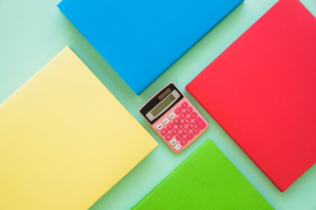 Livros coloridos com calculadora no centro