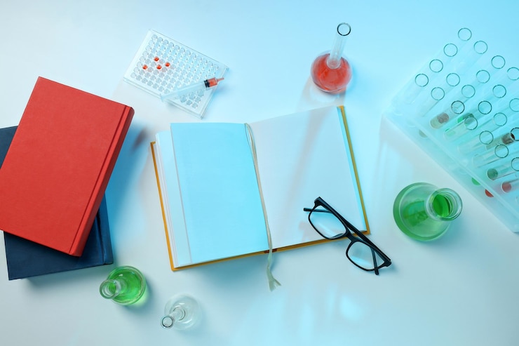 Foto grátis livros com tubos de ensaio químicos na mesa