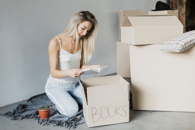 Foto grátis livros de embalagem de mulher de vista frontal