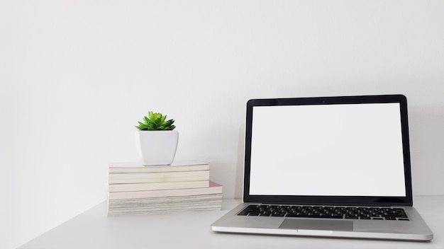 Livros empilhados e laptop na mesa de escritório