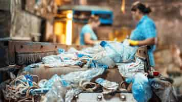 Foto grátis lixo plástico em uma correia transportadora na fábrica de reciclagem de resíduos trabalhadores em segundo plano