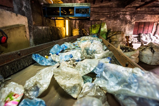 Lixo plástico em uma correia transportadora na fábrica de reciclagem de resíduos