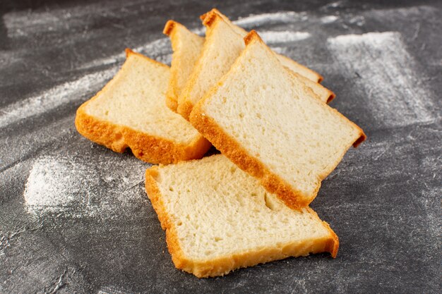 Loafs de pão branco de vista frontal frontal fatiados e saborosos isolados na superfície cinza