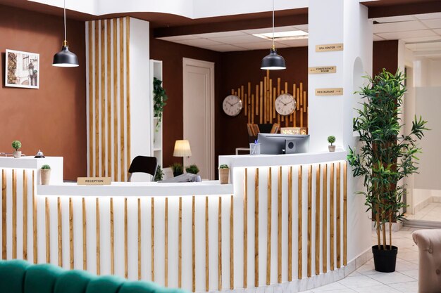 Lobby do hotel com um design impressionante e móveis modernos, acomodações de resort caras com piso de mármore. Recepção vazia com computadores e campainha de serviço, registro.