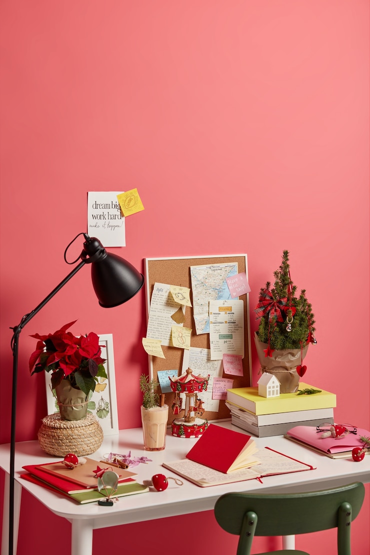 Foto grátis local de trabalho com árvore de natal decorada, bebida de gemada em vidro, notas diferentes com planos futuros e frases de motivação, isolado no fundo rosa