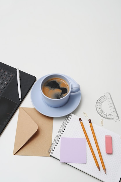 Local de trabalho com computador portátil, café e bloco de notas, vista superior